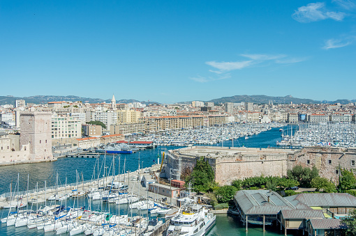 Port of marseille with blue sky, nautical vessel and mountain.