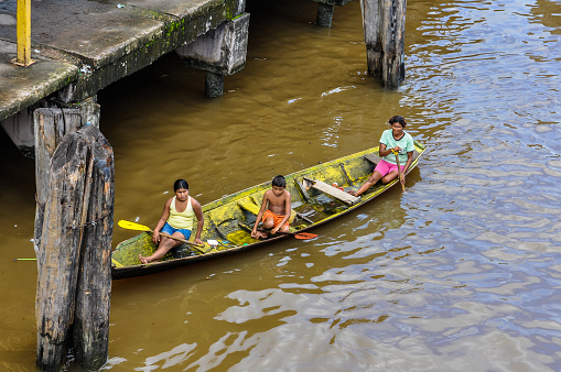 Amazon River, Brazil - May 12, 2012: Local family waiting in a boat on the Amazon River in Brazil.
