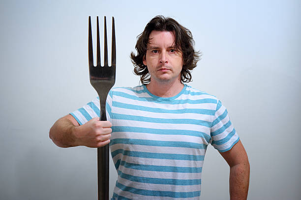 Man with big fork as a Neptune trident stock photo