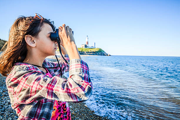 istock Teenage girl exploring ocean with binocular 499243081