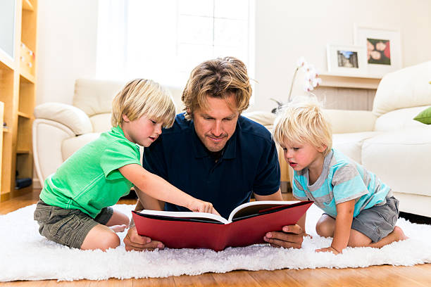 istock Father is reading a book to his two young boys. 499243897