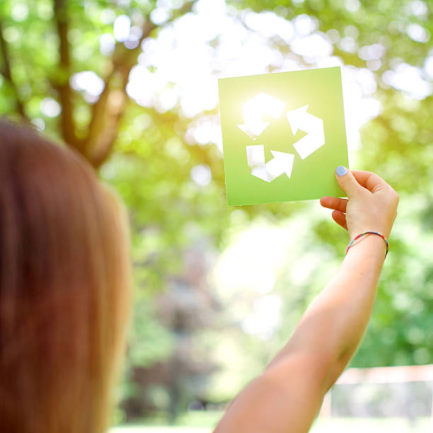 istock Sun shining through recycle sign in woman's hand 499244767