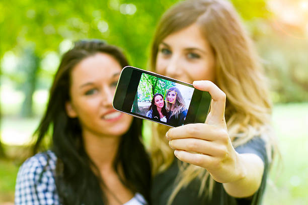 istock Two young girls having fun with smartphone 499245755