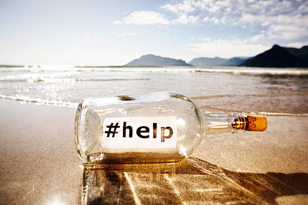 "#помочь», — говорит социальных медиа версия послание в бутылке" - message in a bottle beached bottle desert island стоковые фото и изображения
