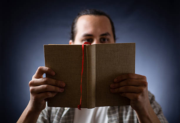 istock young man reading a book in the dark 499253972