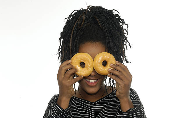 adolescente jugando con donuts - decisions teenage girls horizontal studio shot fotografías e imágenes de stock