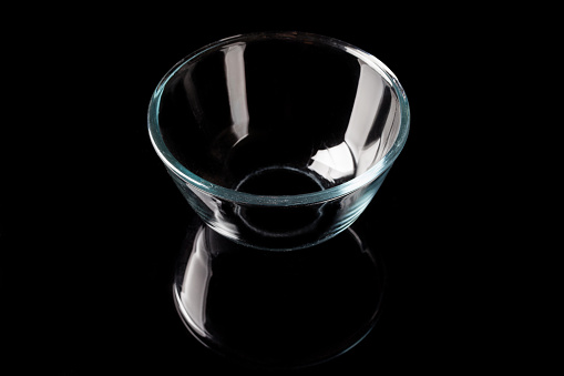 Glass transparent bowl on black background from high angle with reflection