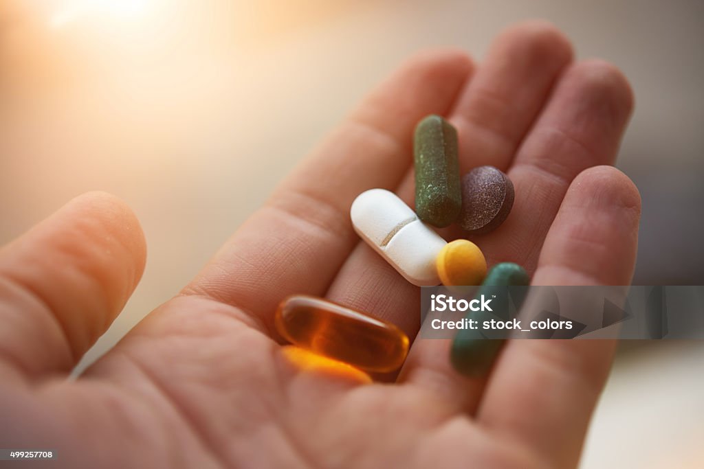 prepared to take my nutritional supplements man hand holding his nutritional supplemets, healthy lifestyle background. Vitamin Stock Photo