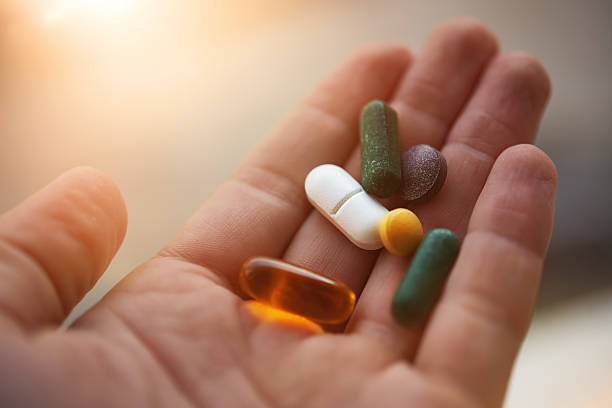 prepared to take my nutritional supplements man hand holding his nutritional supplemets, healthy lifestyle background. vitamin photos stock pictures, royalty-free photos & images