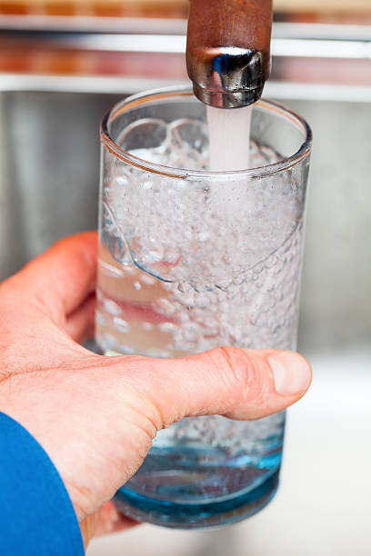 istock Filling up a glass with drinking water from kitchen tap 499258188