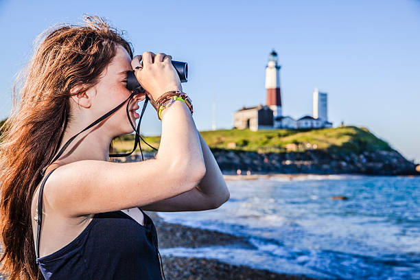 istock Teenage girl exploring ocean with binocular 499258895
