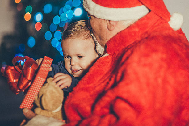 istock Santa Claus Giving Gift To Boy 499260156