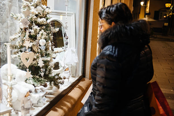 Christmas shop window admired by woman Strasbourg, France - November 28, 2015: Busy Christmas Market Christkindlmarkt in the city of Strasbourg, Alsace region,  France with woman admiring windows of a christmas shop admired stock pictures, royalty-free photos & images