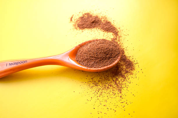 istock Measuring Teaspoon of Cinnamon on Vibrant Yellow Background 499266448