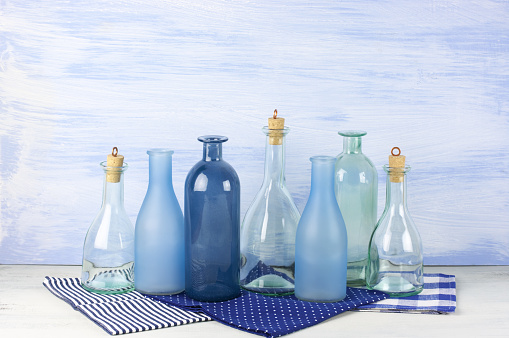 Coolection of decorative bottles on blue wooden background.