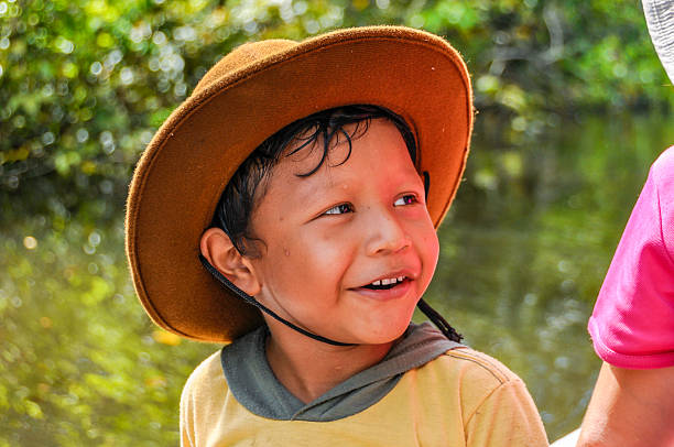 Manaus, Brazil - May 19, 2012: Local kid smiling at us wihile sitting in a boat in the Amazon Rainforest, close to Manaus, Brazil.