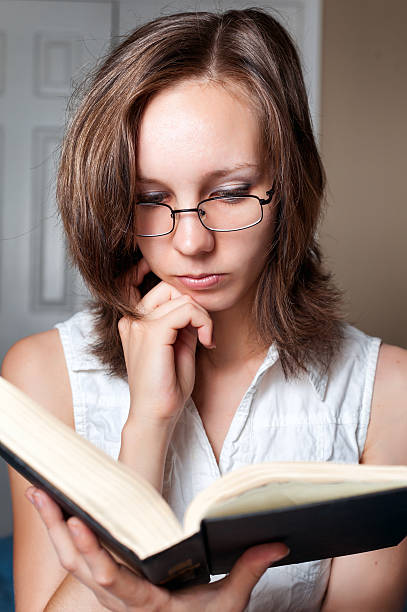 istock Cute student girl wearing eyeglasses with book 499280831