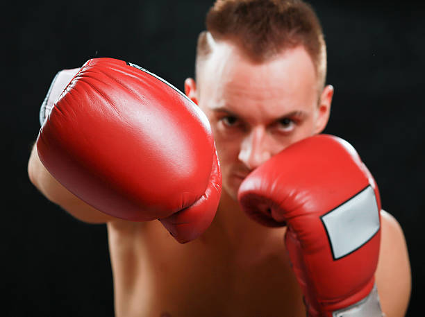 istock Young boxer man isolated on black background 499281295