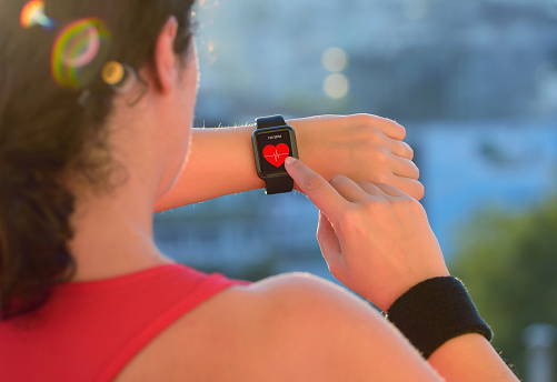Woman using smart watch before exercising. 