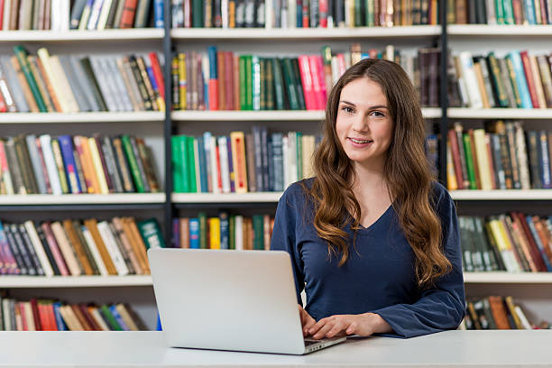 istock girl sitting at a desk in library 499284030