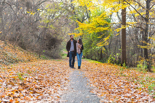 istock Young couple walking through the park 499284350
