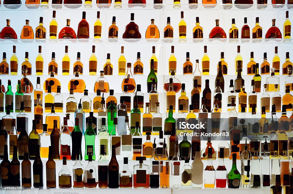 Various alcohol bottles in a bar Various alcohol bottles in a bar, back light, all logos removed Bottle Stock Photo