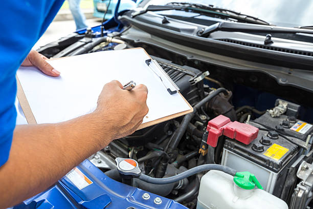 mechanik trzyma schowka i sprawdzić samochód - auto repair shop adult auto mechanic blue zdjęcia i obrazy z banku zdjęć