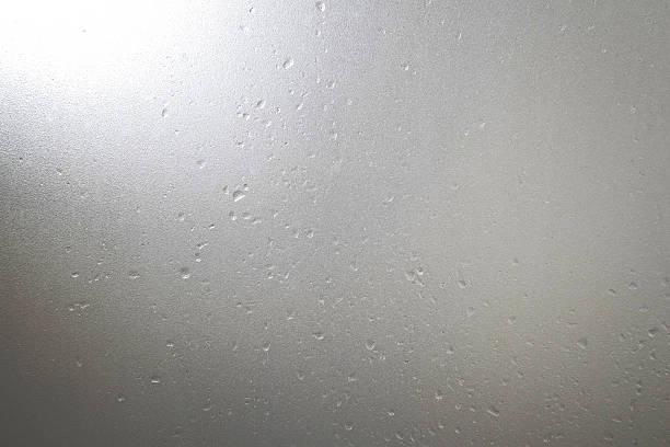 Frosted glass with water drops and bright light at corner Frosted glass with water drops and bright light at corner heat haze stock pictures, royalty-free photos & images