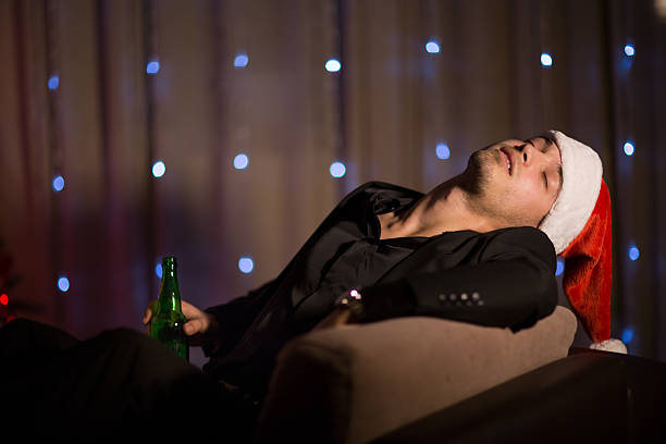 istock Drinking and sleepy Christmas man in santa's hat 499309800