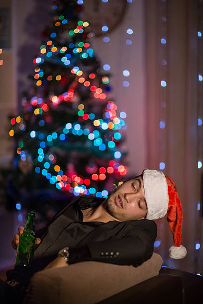 istock Drinking and sleepy Christmas man in santa's hat 499310012