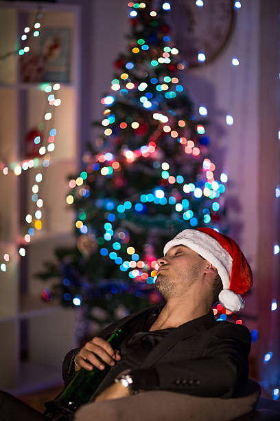 istock Drinking and sleepy Christmas man in santa's hat 499310132