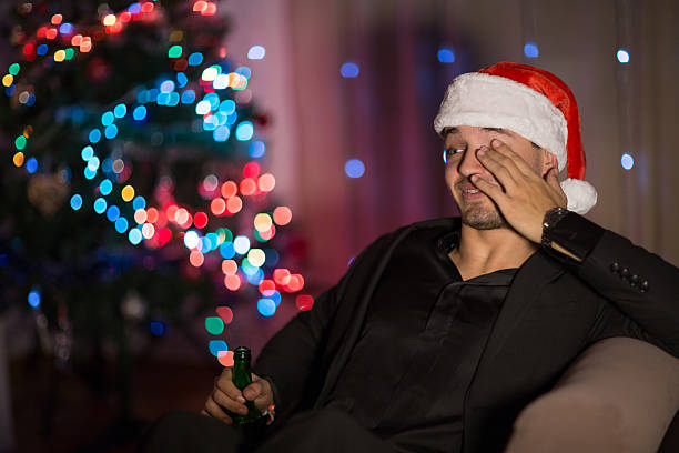 istock Drinking and sleepy Christmas man in santa's hat 499310306