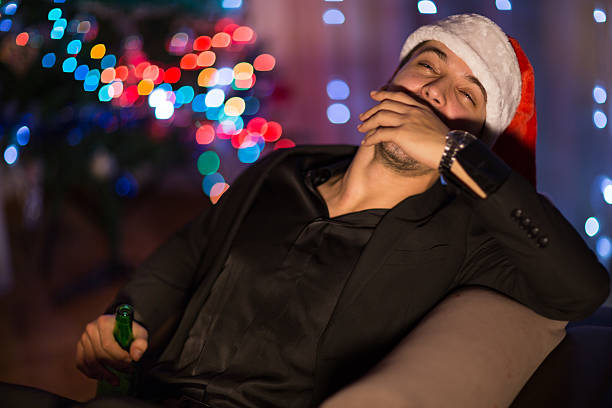 istock Drinking and sleepy Christmas man in santa's hat 499310392
