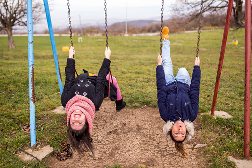 Young women fooling around,laughing and swinging upside down