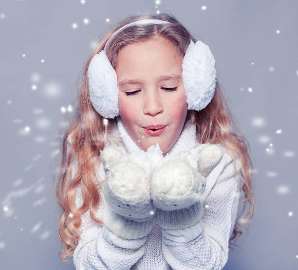 istock Girl blowing on the snow 499315304