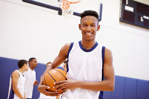 An African American basketball player holding a ball on the courts. Closeup of a fit and talented male athlete about to shoot hoops at training in a sports club. A young active man enjoying his hobby