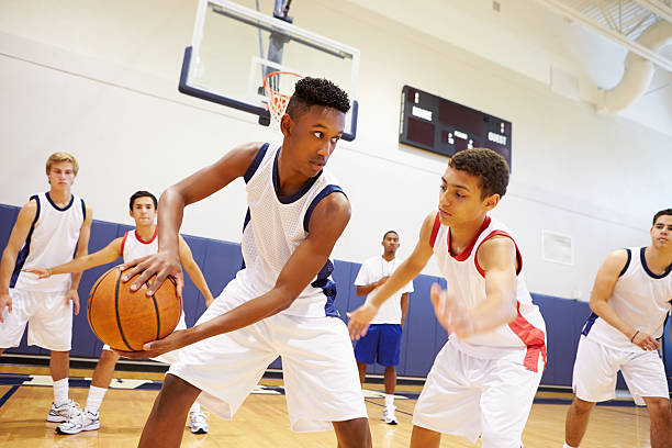 Male High School Basketball Team Playing Game Male High School Basketball Team Playing Game In Gymnasium 16 17 years stock pictures, royalty-free photos & images