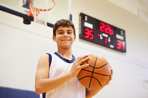 Portrait Of Male High School Basketball Player Holding Basketball