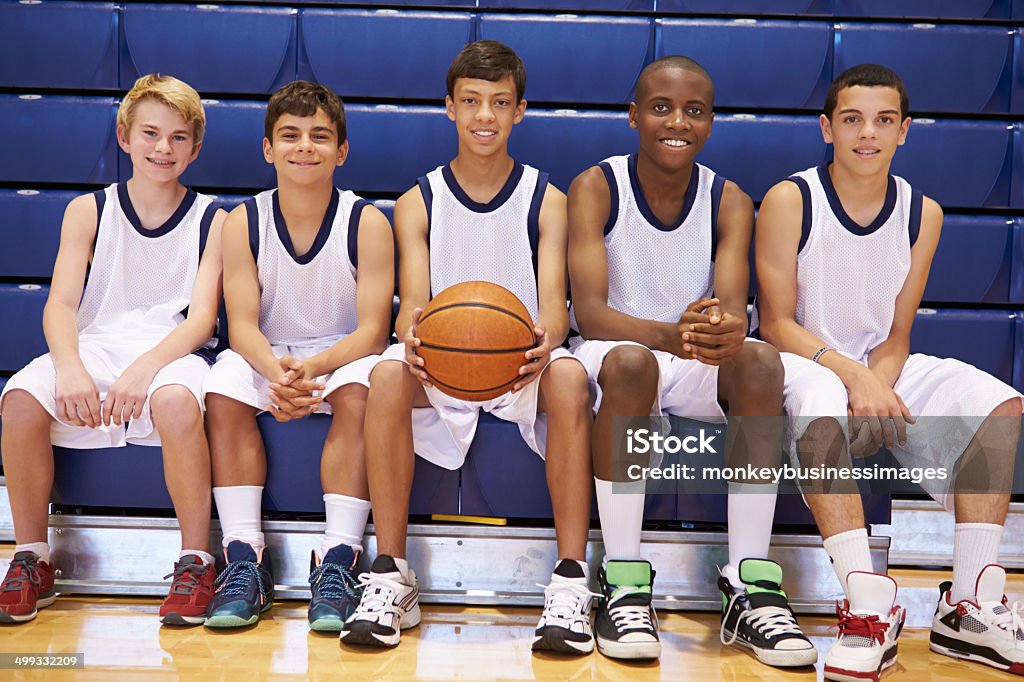 Members Of Male High School Basketball Team On Bench Members Of Male High School Basketball Team On Bench Smiling Basketball Team Stock Photo