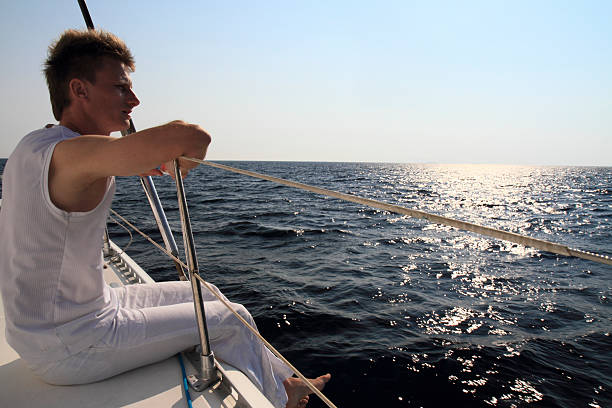 istock Young man enjoying the view from sailing boat 499332562