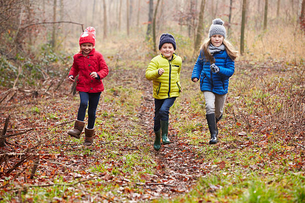 istock Three Children Running Through Winter Woodland 499333503