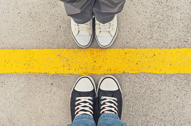 Sneakers from above. Sneakers from above. Male and female feet in sneakers from above, standing at dividing line. boundary stock pictures, royalty-free photos & images