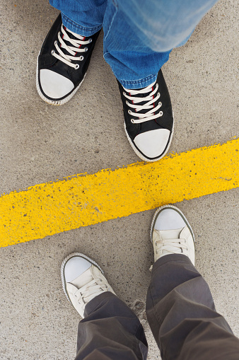 Sneakers from above. Male and female feet in sneakers from above, standing at dividing line.
