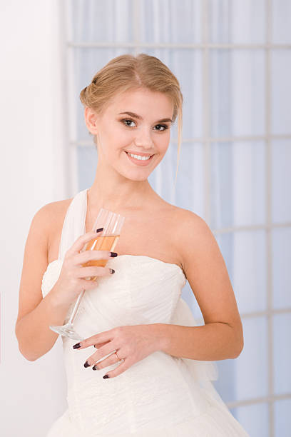 a girl in light clothes with a glass in her hand on a pink background