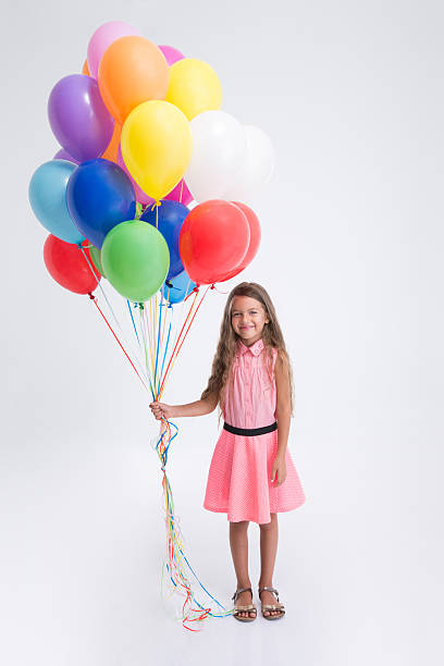 istock Pretty little girl standing with balloons 499337320