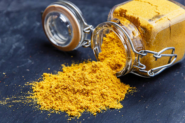 powder seasoning spice turmeric on a black stone powder seasoning spice turmeric on a black stone curry stock pictures, royalty-free photos & images