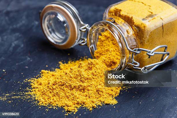 Powder Seasoning Spice Turmeric On A Black Stone Stock Photo - Download Image Now - Curry Powder, Curry - Meal, Spice