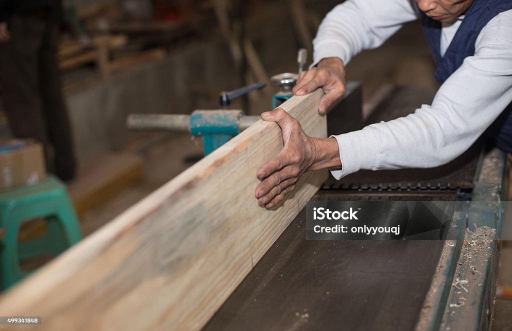 Carpentry. Carpenter working in his workshop Carpenter cutting wood on electric saw, focus is on the blade of the tool - a series of INDUSTRIAL IMAGES.Carpentry. Carpenter working in his workshopCarpentry. Carpenter working in his workshop 2015 Stock Photo