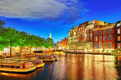 Famous Amstel river and night view of beautiful Amsterdam city. NetherlandsFamous Amstel river and night view of beautiful Amsterdam city. Netherlands