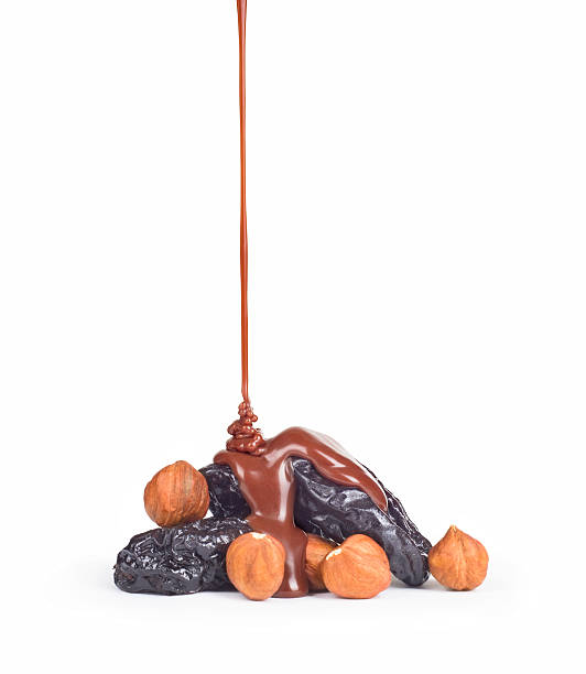 istock Dried plums with nuts in a row with melting chocolate 499365908